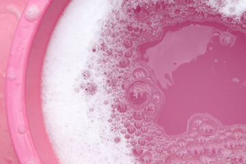 White detergent foam bubble, pink background.