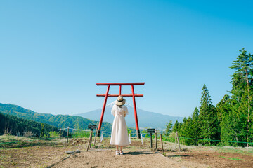 富士山をまつる神社でお参りする女性