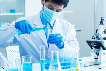 Scientist man holding chemical test glass tube testing science laboratory. Doctor clinic healthcare lab technician diagnosis sample. Asian man scientist working vaccine test medical biochemistry lab