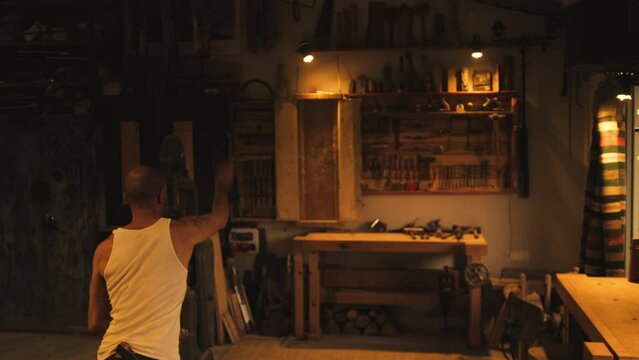 Man throwing knives at target indoors