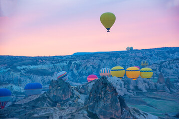 Sunrise in Cappadocia with colorful hot air balloons fly in sky over canyons, valleys morning tourist destination. Travel Turkey concept
