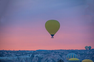 Sunrise in Cappadocia with colorful hot air balloons fly in sky over canyons, valleys morning tourist destination. Travel Turkey concept
