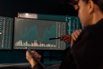 Focusing on dynamic stock exchange statistic on pc screens with hand pointing, comparing data on...