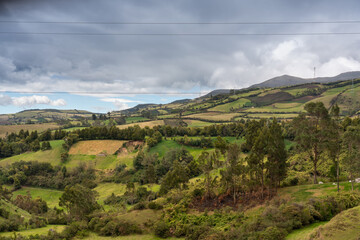 View of a Colombian landscape with crop fields between hills.