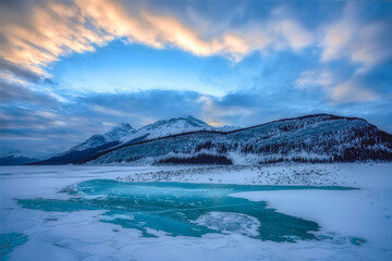 Beautiful mountain and sky view at Spray lake as foreground. Entire lake has frozen over, some...