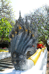 Centuries-year-old Naga statue at the railing of an old Buddhist temple that enshrines the Buddha's...