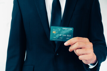Portrait of businessman holding a credit card showing front view to the camera in close up view....