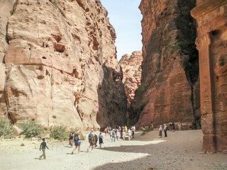 Numerous tourists travel through remains of Nabatean buildings in Petra historical center in the...