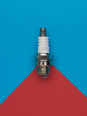 A short spark plug on a two-tone background.