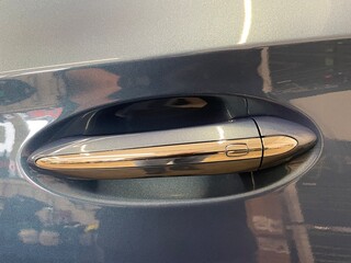 Manija de auto con detalles en cromo con forma ovalada y sensor de apertura. 