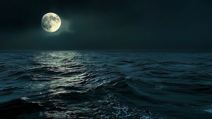 The dramatic contrast between the dark ocean at night and the bright full moon, emphasizing the calm yet powerful nature of the sea