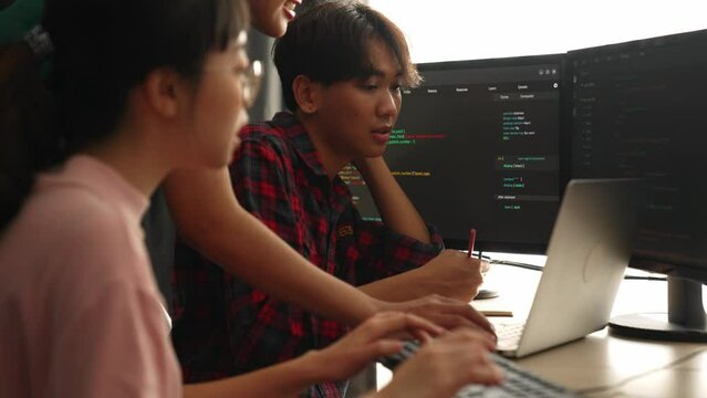 Slow motion back end software developer engineer for computer programming working together on debugging writing computing code, solving complex algorithms display on monitor in office. Burgeoning