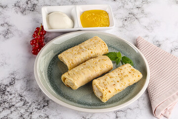 Homemade stuffed pancakes with honey and cream sour