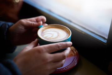 Hands, coffee and cappuccino in cafe for winter, travel and customer in restaurant for breakfast....