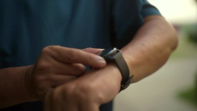 Close up of Senior old man using smart watch running at park. Grandfather jogging with smart watch outdoor. Workout exercise in the morning. Healthy Aging Society concept.