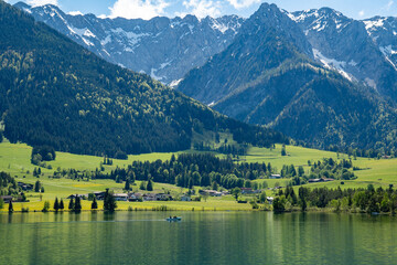 A boat on Lake Walchsee, Tyrol, Austria. View of pasture meadows in front of the Zahmer Kaiser...