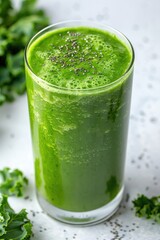Close up of a glass of green vegetable juice on a table