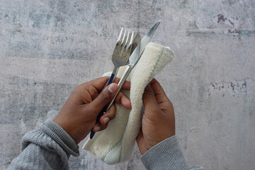  person hand cleaning and drying cutlery with a towel