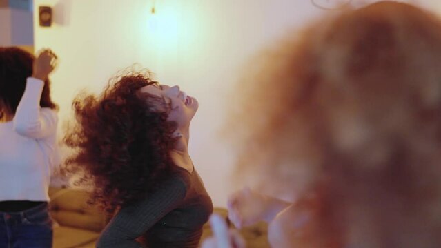 Happy group of multiethnic friends dancing at home
