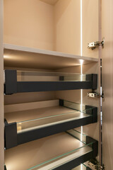 Inside the wardrobe there are shelves, sliding rails and LED lights.