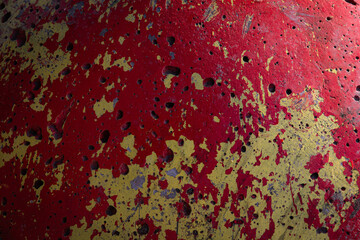 Stone porous surface painted in yellow and red colors.