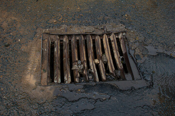 An old dented metal drain grate.