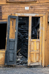 The burnt door of an old wooden house.