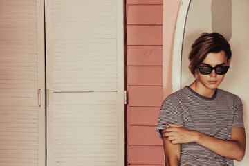 Early morning. A young attractive guy is relaxing near a bungalow.