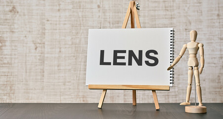 There is notebook with the word LENS. It is as an eye-catching image.