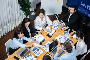Wide top view of diverse group of business analyst team analyzing financial data report paper on...