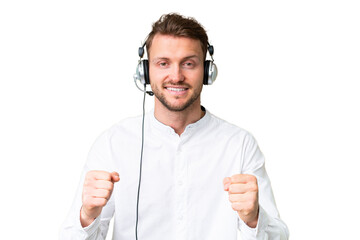 Telemarketer caucasian man working with a headset over isolated chroma key background celebrating a...