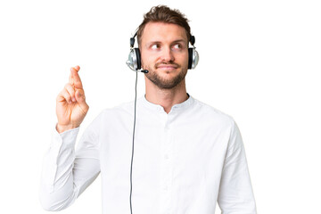 Telemarketer caucasian man working with a headset over isolated chroma key background with fingers...