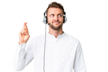 Telemarketer caucasian man working with a headset over isolated chroma key background with fingers crossing and wishing the best