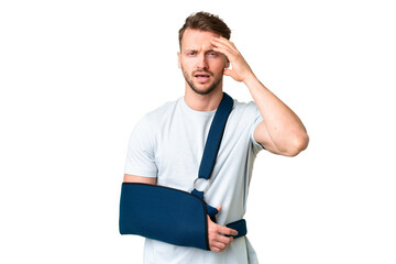 Young caucasian man with broken arm and wearing a sling over isolated chroma key background with...