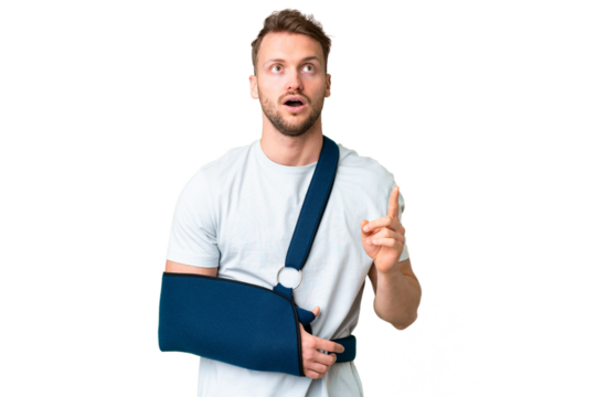 Young caucasian man with broken arm and wearing a sling over isolated chroma key background thinking an idea pointing the finger up