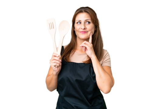 Middle age caucasian woman holding a rolling pin over isolated background thinking an idea while looking up