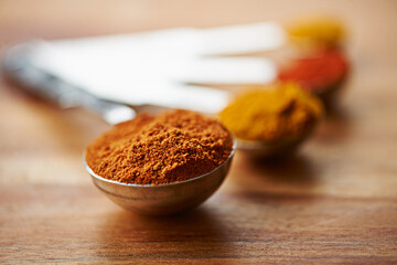 Spoons, spice and collection of powder for cooking on kitchen table, turmeric and paprika for meal....