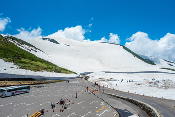 Parking spot for tourists snow mountains wall of Tateyama Kurobe alpine with blue sky background is...