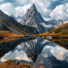 A sharp, towering mountain peak is mirrored perfectly in the calm waters of a serene alpine lake...