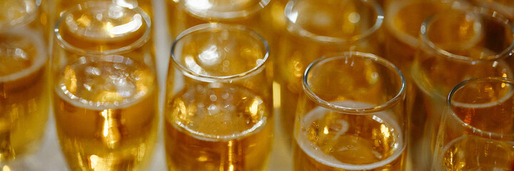 Close-up of multiple glasses filled with bubbly golden champagne, bubbles. Concept for...