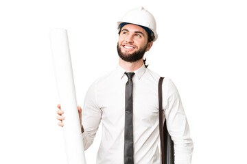 Young architect man with helmet and holding blueprints over isolated chroma key background thinking...