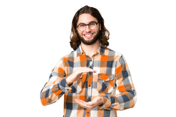 Young handsome man over isolated chroma key background holding copyspace imaginary on the palm to...