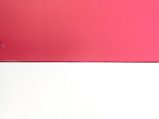 White and pinkish-red painted wooden background with space for text.