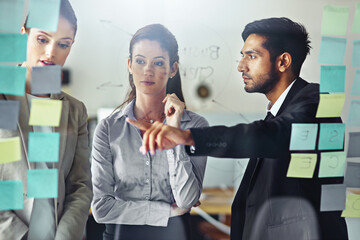 Business people, planning and talking in office with glass wall for brainstorming, teamwork and...