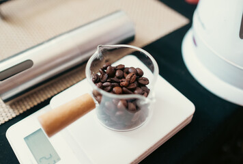 Coffee bean  on top of a digital coffee scale preparing for coffee brewing