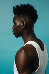 Side Profile of Young Black Man with Modern Hairstyle Against Blue Background