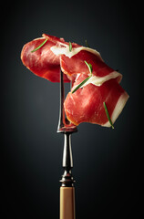 Sliced prosciutto with rosemary.