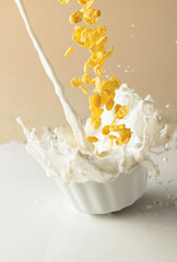 Dry honey cornflakes with milk splashes in a ceramic plate.
