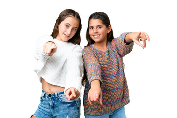 Friends girls over isolated chroma key background points finger at you with a confident expression