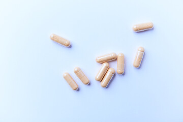 Lutein capsules. Dietary supplement on bright paper background. Soft focus. Top view. Close up. Copy space.